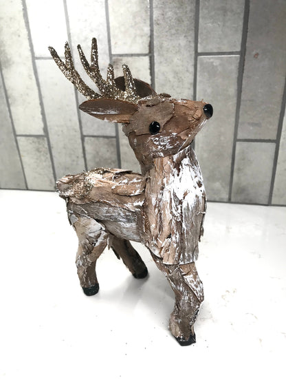Decorative deer figure with metallic finish on a white surface and tiled wall background