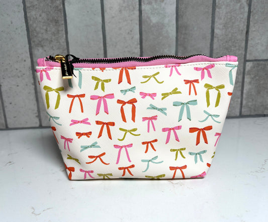 Colorful bow print cosmetic makeup bag with pink zipper and gold hardware, cute ribbon pattern travel pouch gift from Square 1 Boutique Alabama