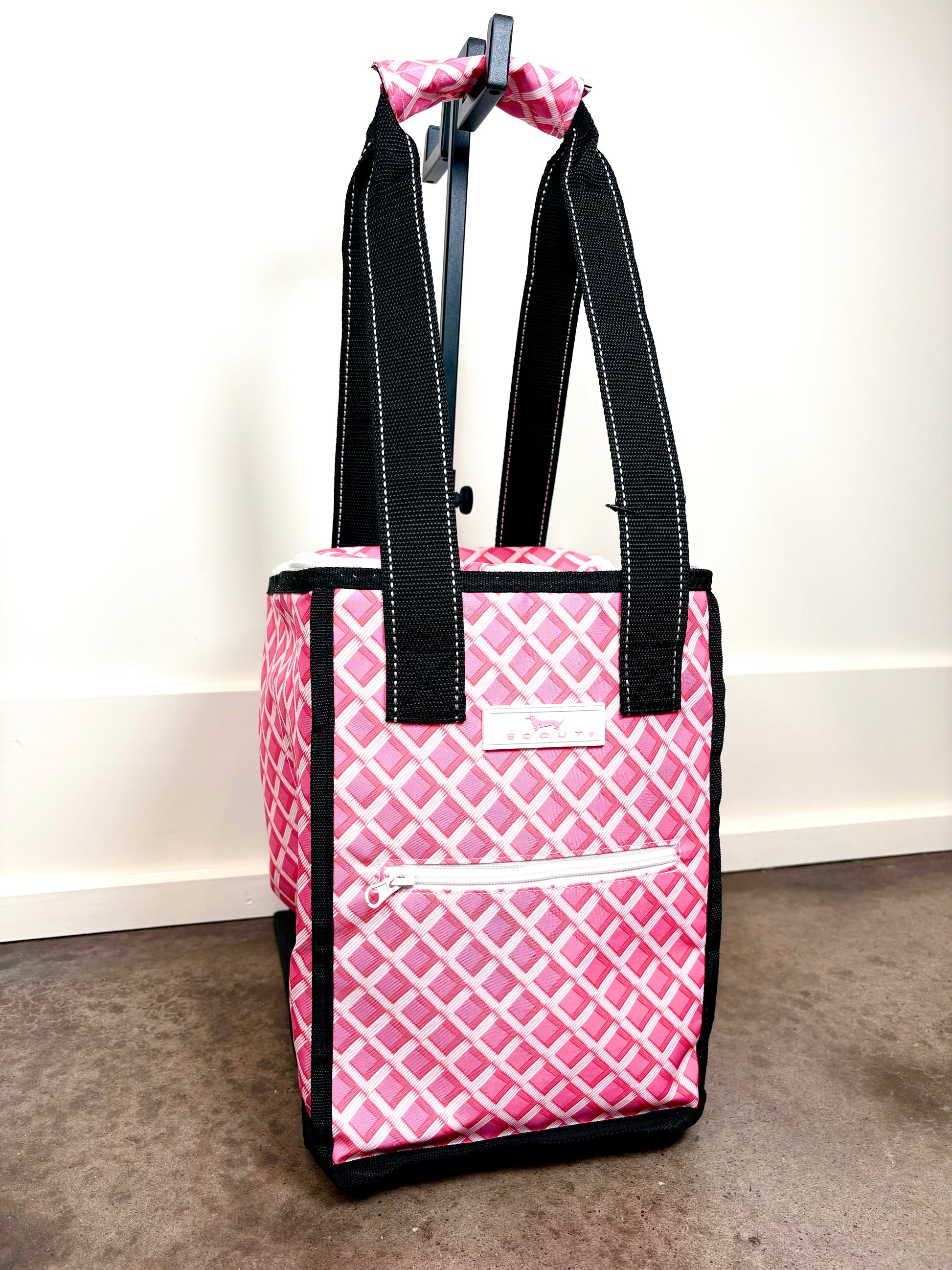 Angled view of Pleasure Chest Cooler in Garden Gate pink lattice pattern, structured insulated cooler bag with front zip pocket and reinforced straps.
