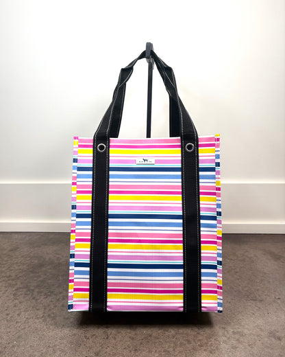 Bagette Market Tote Bag in Stripe a Pose with colorful horizontal stripes, structured reusable tote with black handles.