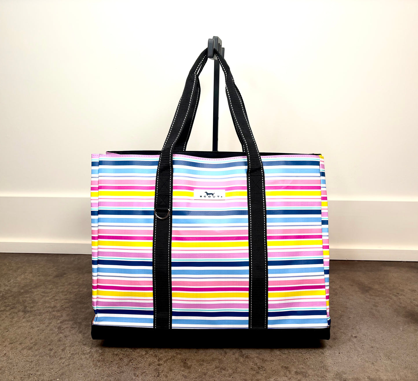 Original Deano Tote Large Bag in Stripe a Pose with colorful horizontal stripes, large reusable tote with black handles and structured bottom.