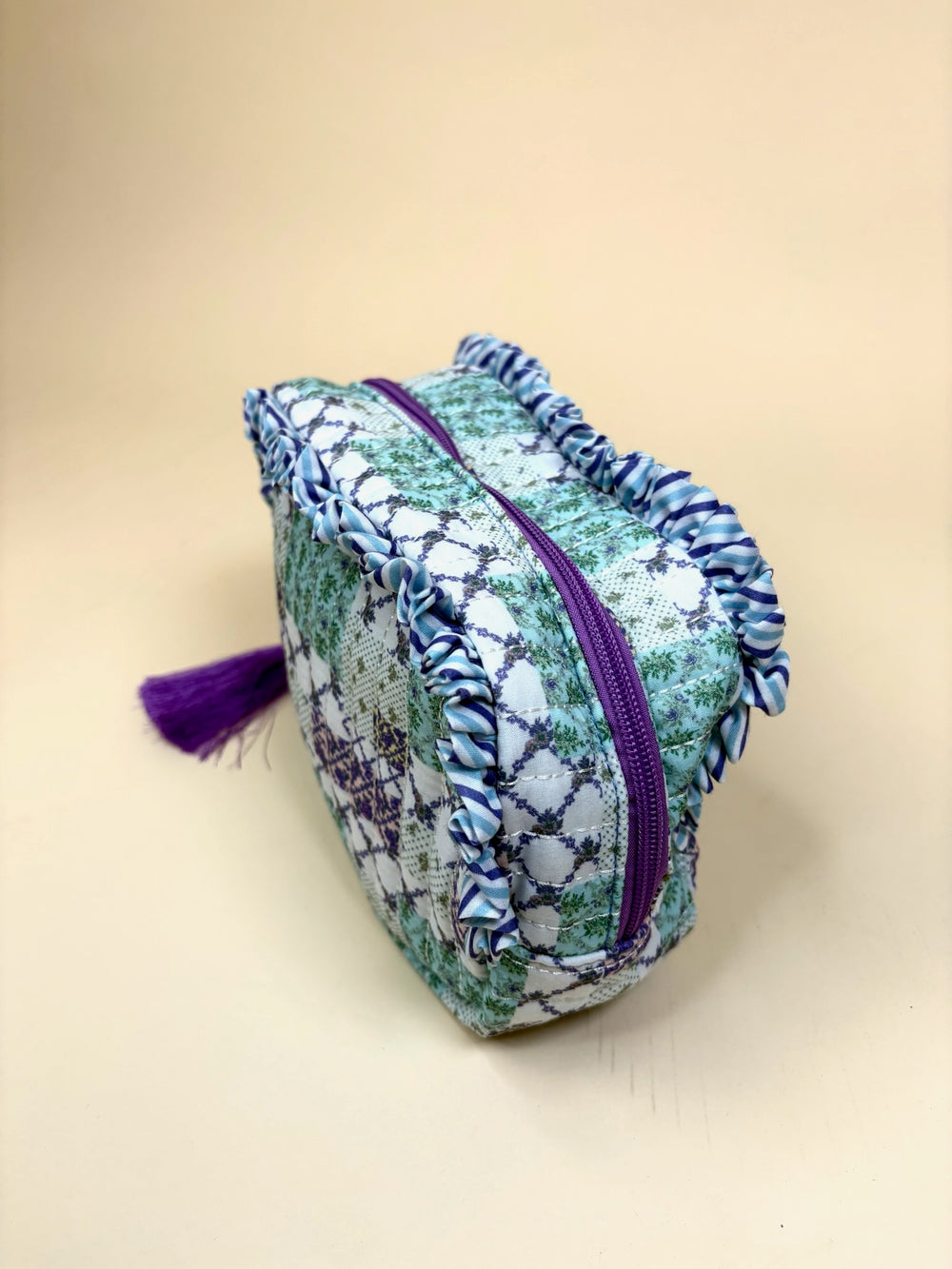 Side view of the Simply Southern Trail Patch quilted cosmetic makeup bag featuring purple zipper, ruffle trim, and tassel pull.