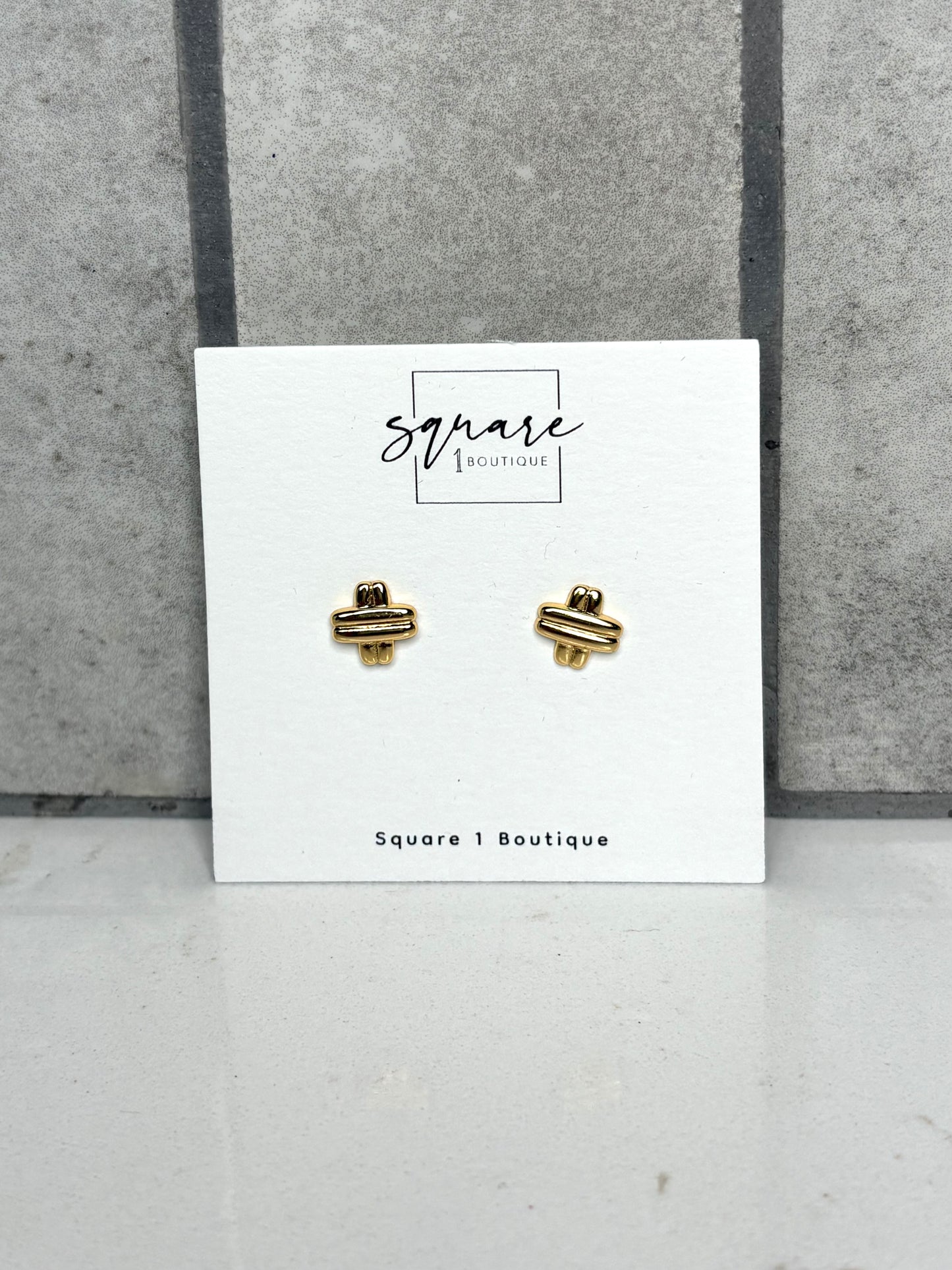 Gold knot stud earrings on Square 1 Boutique card – dainty everyday women’s jewelry accessory