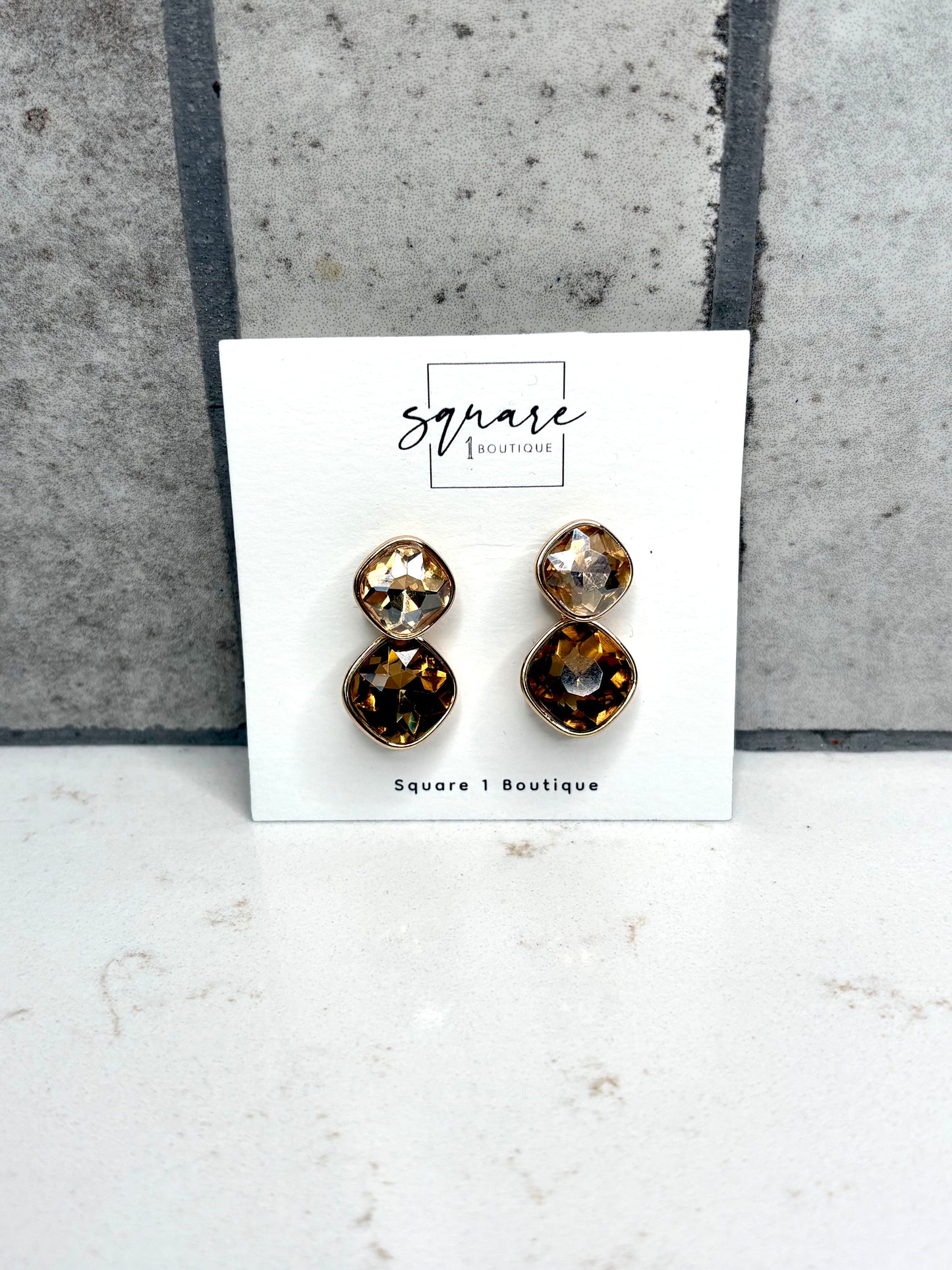 Gold double crystal drop earrings in champagne and amber tones on Square 1 Boutique card – women’s boutique accessories