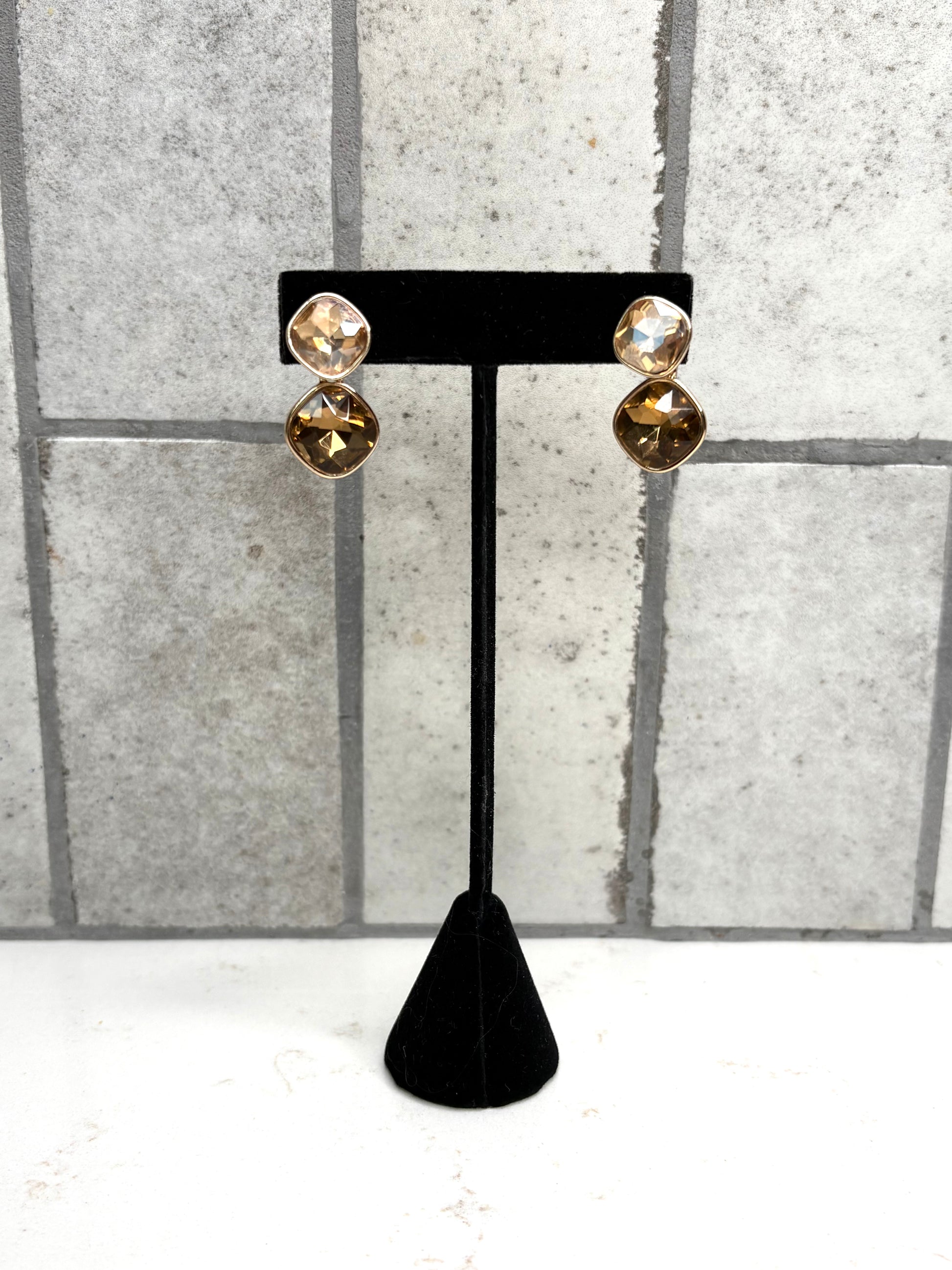 Gold double stone drop earrings with champagne and amber crystals on black display stand – elegant boutique jewelry