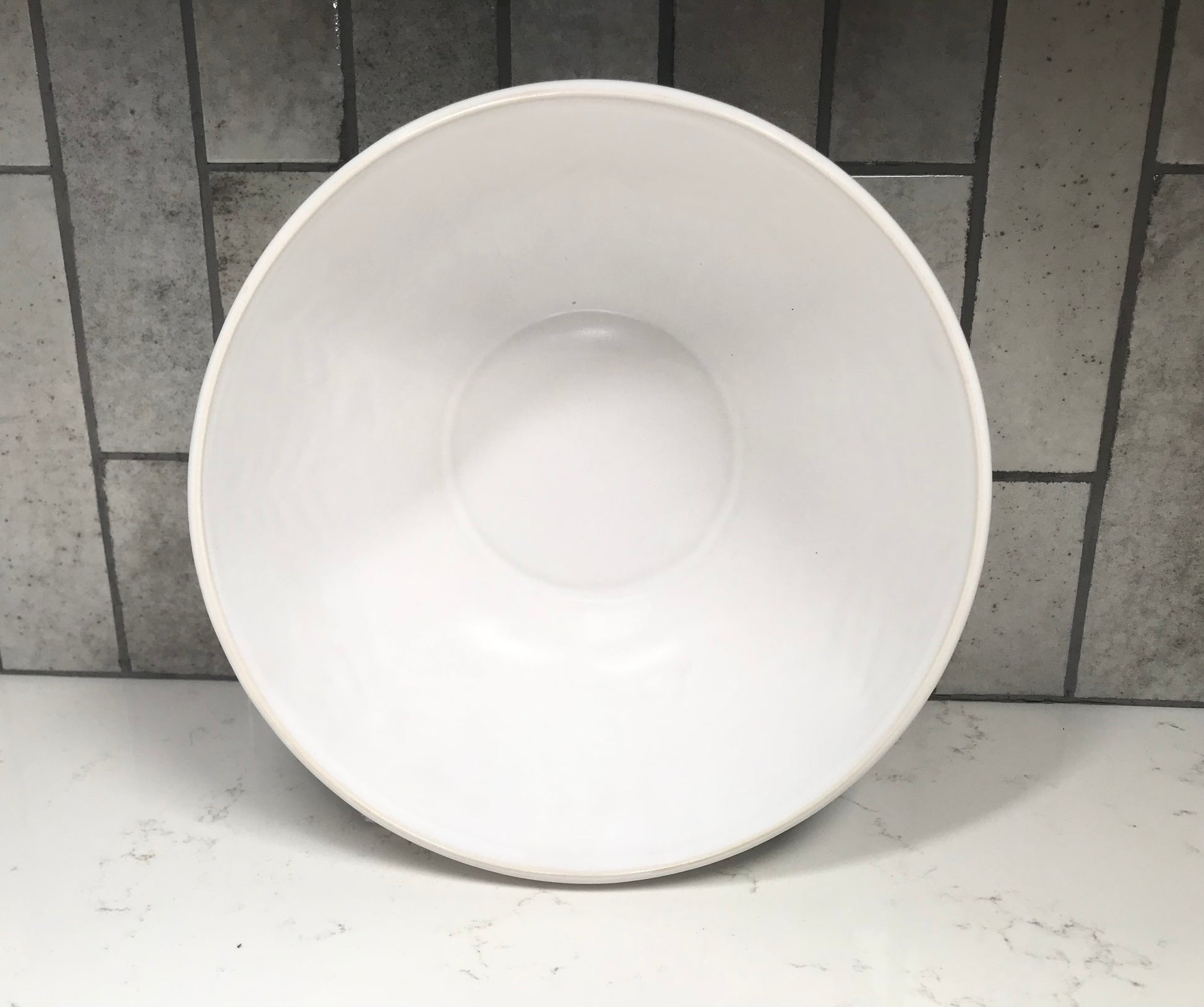 White ceramic bowl on a tiled floor