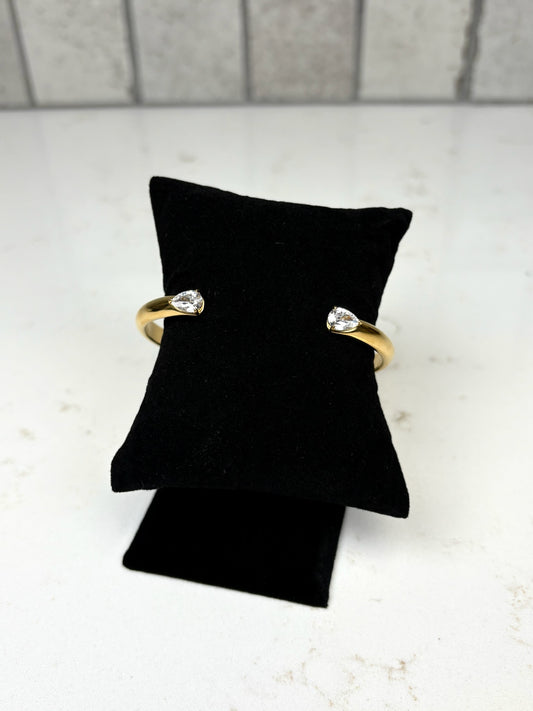 Chan Sutt Pearl gold open cuff bracelet with pear-shaped crystal ends on black display pillow