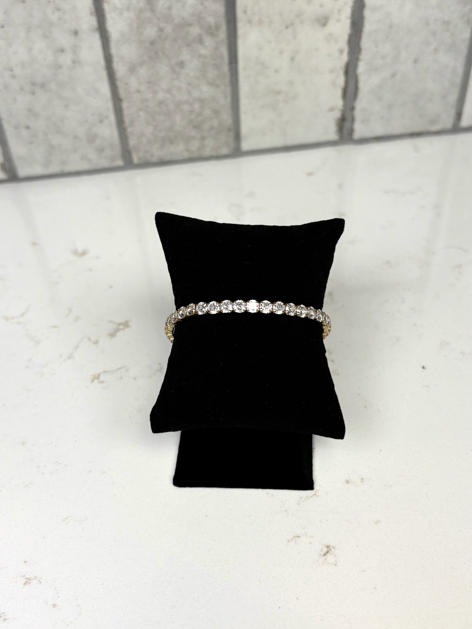 Chan Sutt Pearls thick stretchy tennis bracelet gold crystal bracelet on black display pillow – classic statement jewelry