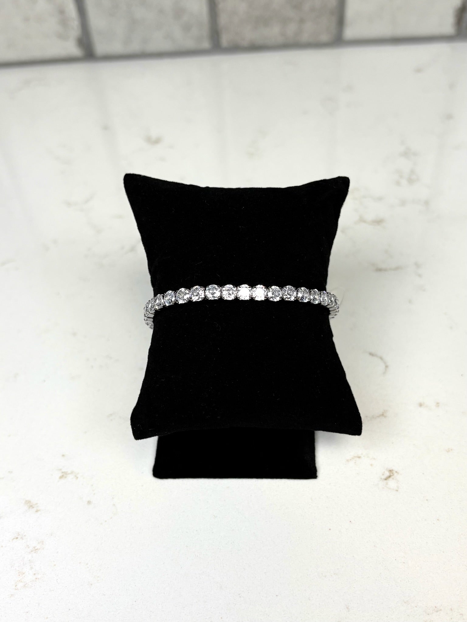 Chan Sutt Pearl silver stretchy tennis bracelet with round crystal stones on black display pillow