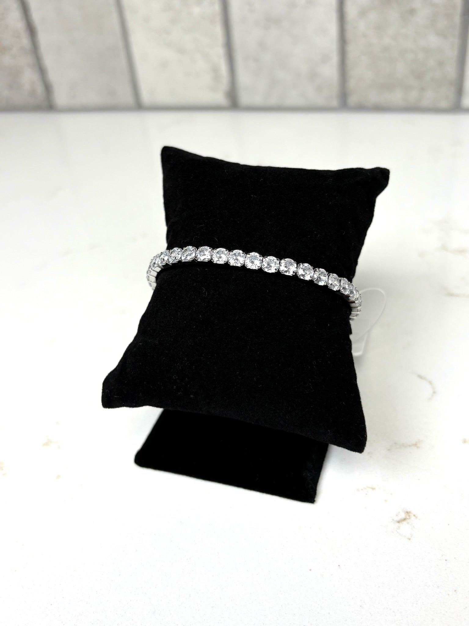 Chan Sutt Pearl silver crystal tennis bracelet stretch design side view on black cushion