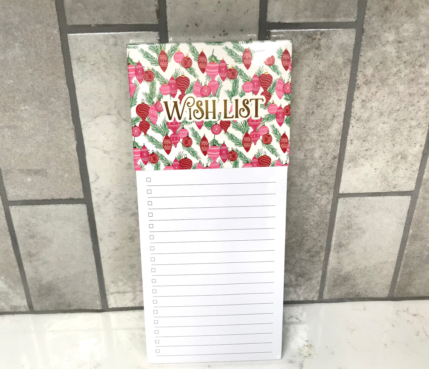 Notepad with floral design and 'Wish List' text on a tiled floor background