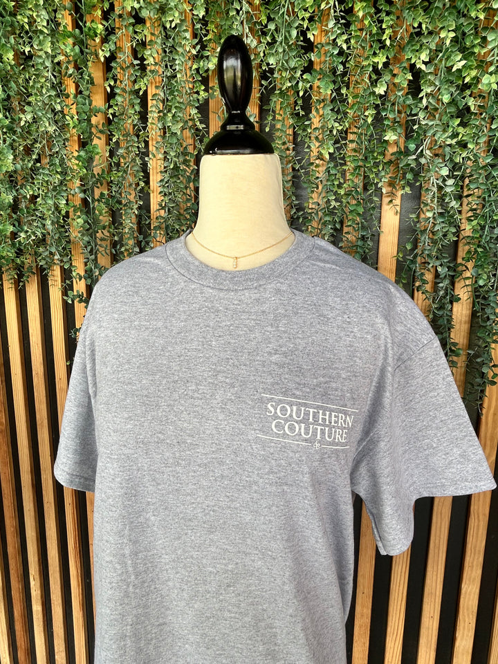 Front view of the Southern Couture Stethoscope Bow Graphic Tee featuring a heather gray 100% cotton short sleeve t-shirt with a small Southern Couture logo on the left chest.
