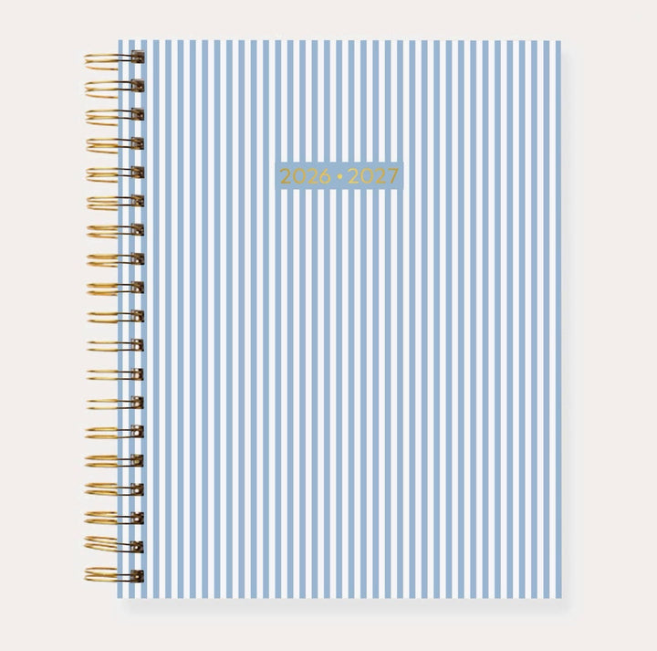 Elyse Breanne Designs 2026–2027 Academic Planner in the Blue Stripes pattern featuring classic light blue and white vertical stripes, gold spiral binding, and a durable soft-touch laminated cover.