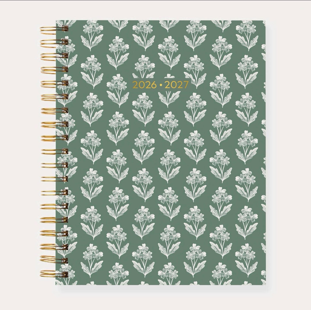 Elyse Breanne Designs 2026–2027 Academic Planner in the Forget Me Nots pattern featuring a colorful floral print with pink, blue, orange, and green blooms, accented by gold spiral binding and a premium laminated cover.