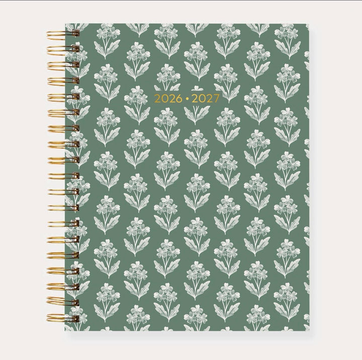 Elyse Breanne Designs 2026–2027 Academic Planner in the Forget Me Nots pattern featuring a colorful floral print with pink, blue, orange, and green blooms, accented by gold spiral binding and a premium laminated cover.