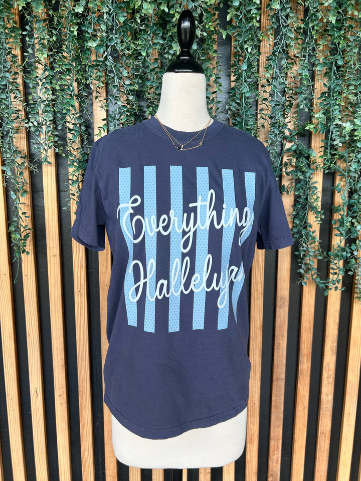 Navy Everything Hallelujah Christian graphic t-shirt displayed on mannequin with blue striped design.