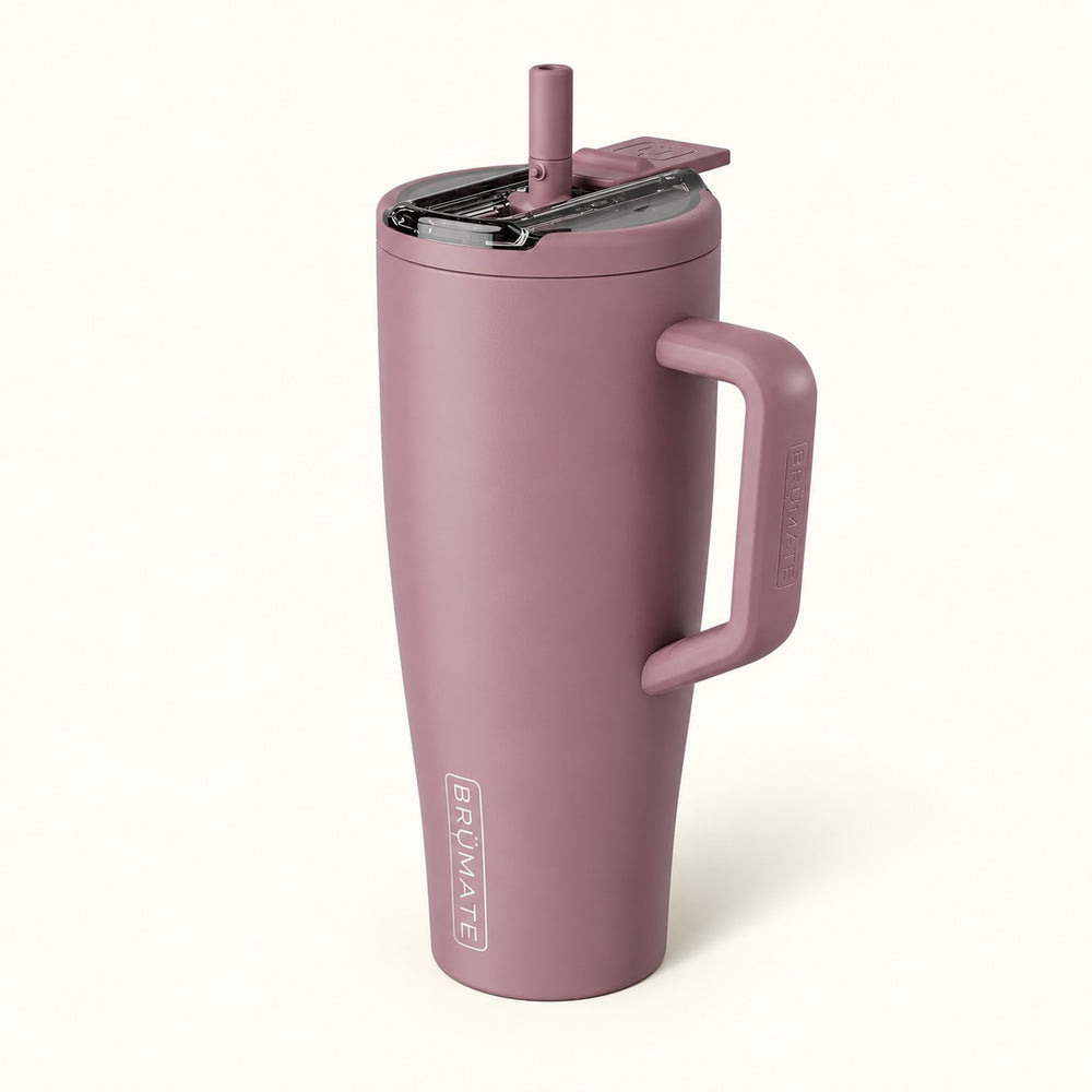 BrüMate Era Flip 40oz insulated straw tumbler in Rose Taupe featuring a muted dusty mauve finish, large coordinating carrying handle, covered flip-down straw lid shown open, and vertical white BrüMate branding. The tall 40oz leakproof water tumbler has a cupholder-friendly base and is displayed against a soft cream studio background.