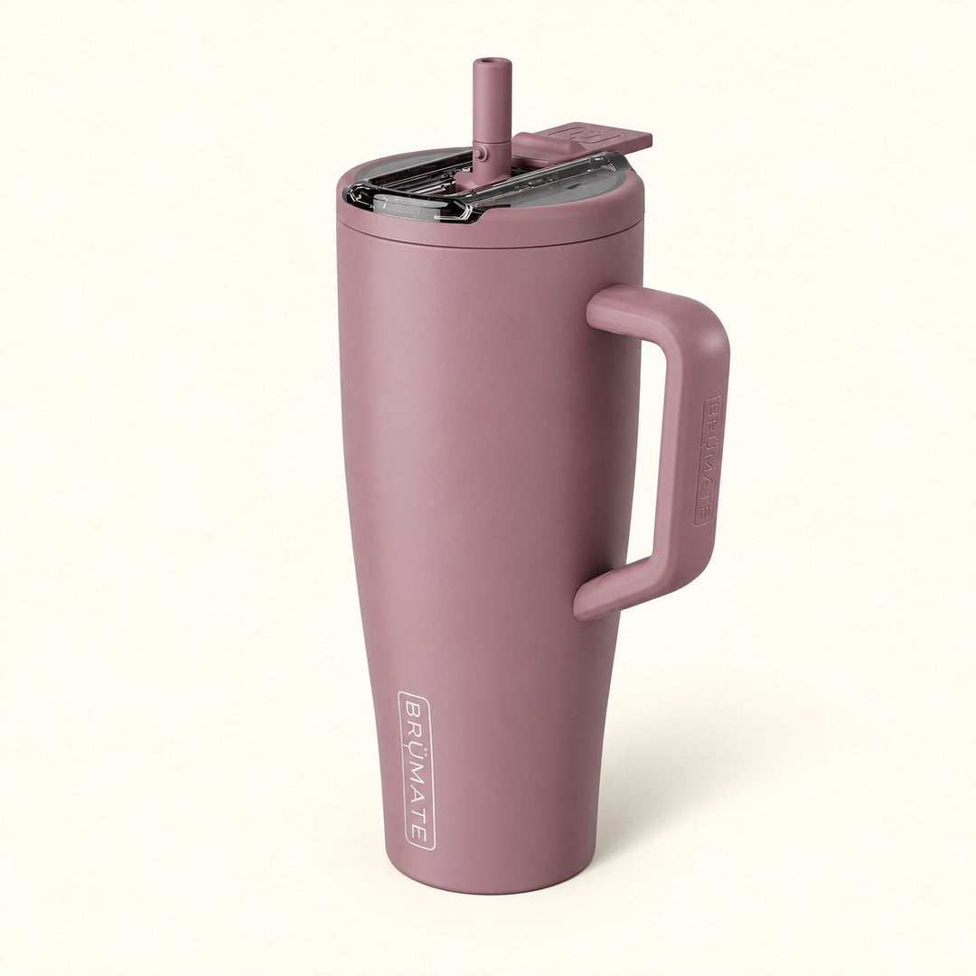 BrüMate Era Flip 40oz insulated straw tumbler in Rose Taupe featuring a muted dusty mauve finish, large coordinating carrying handle, covered flip-down straw lid shown open, and vertical white BrüMate branding. The tall 40oz leakproof water tumbler has a cupholder-friendly base and is displayed against a soft cream studio background.