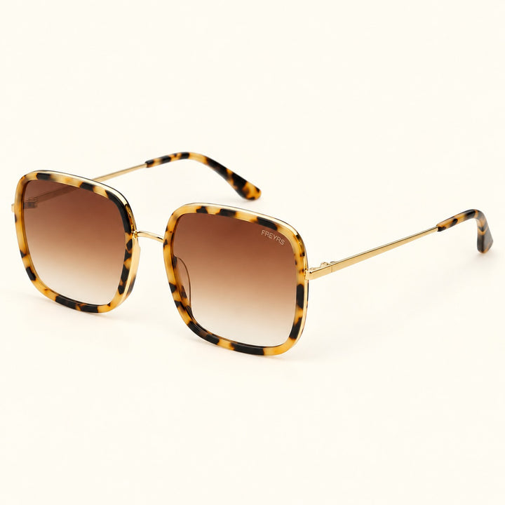 Angled view of FREYRS Cosmo Milky Tortoise square sunglasses showing oversized acetate frames, brown gradient lenses, slim gold-tone temples, and tortoiseshell tips.