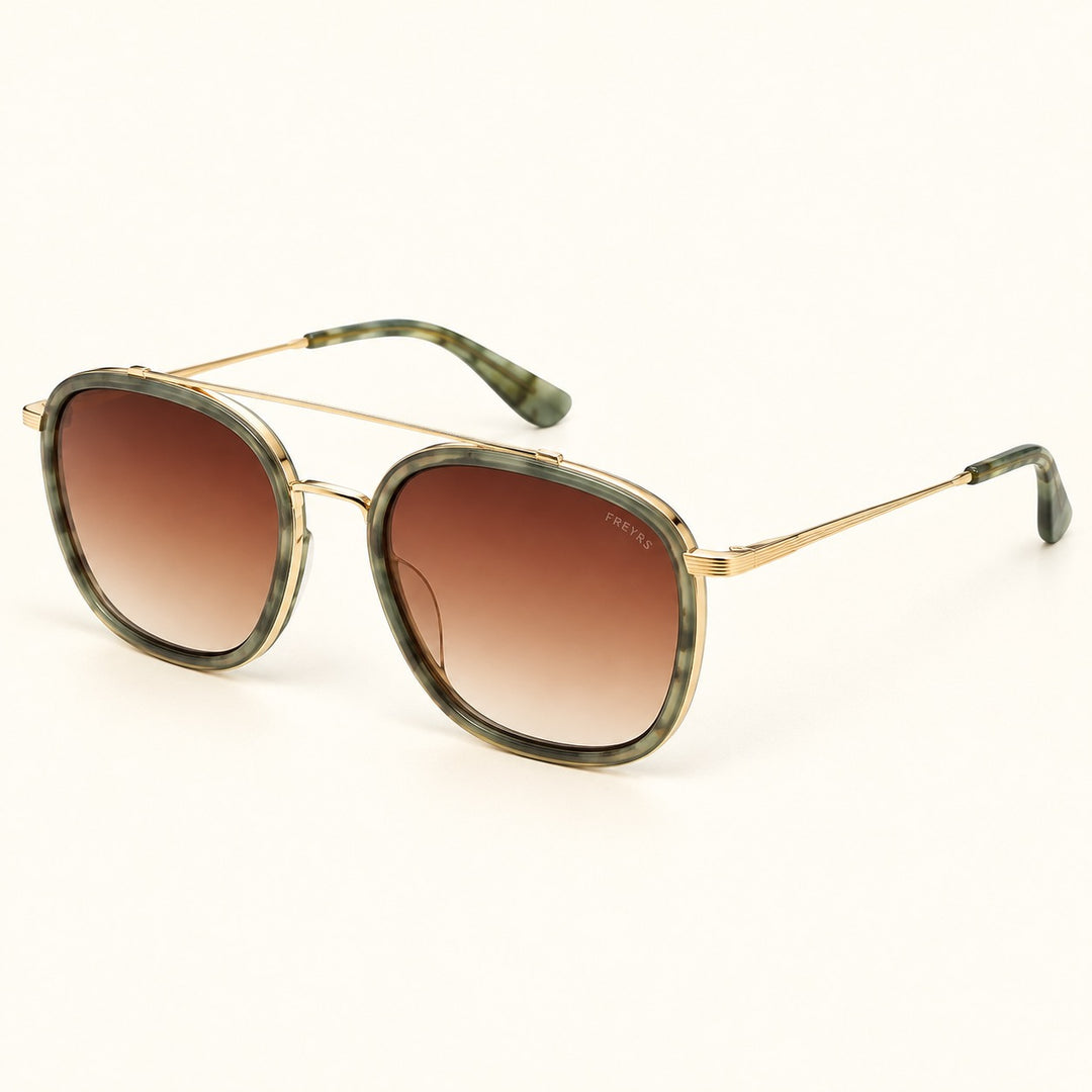 Angled view of FREYRS Weston Emerald sunglasses showing green patterned acetate frames, brown gradient lenses, slim gold-tone temples, and matching green tips.