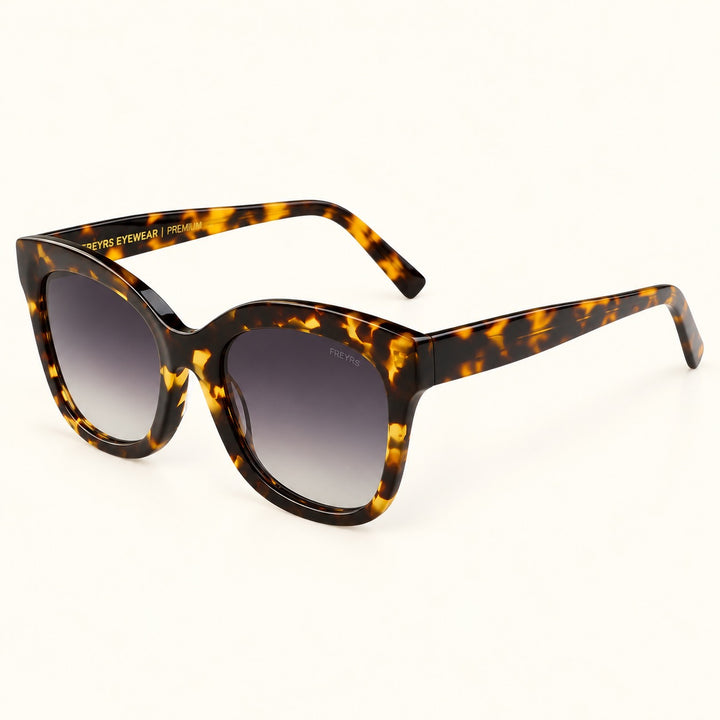 Front view of FREYRS Naples Tortoise Cat Eye Sunglasses showing oversized upswept acetate frames, dark brown and amber tortoiseshell pattern, and gray gradient lenses.