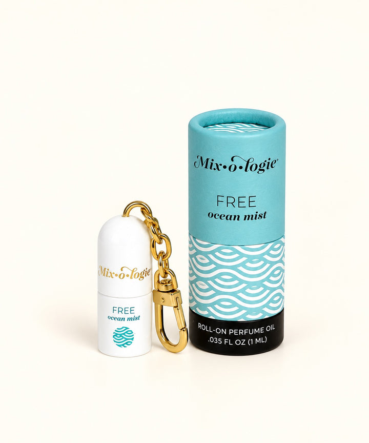 Mixologie Free Ocean Mist mini roll-on perfume keychain with gold clasp, white perfume bottle, and turquoise patterned packaging.