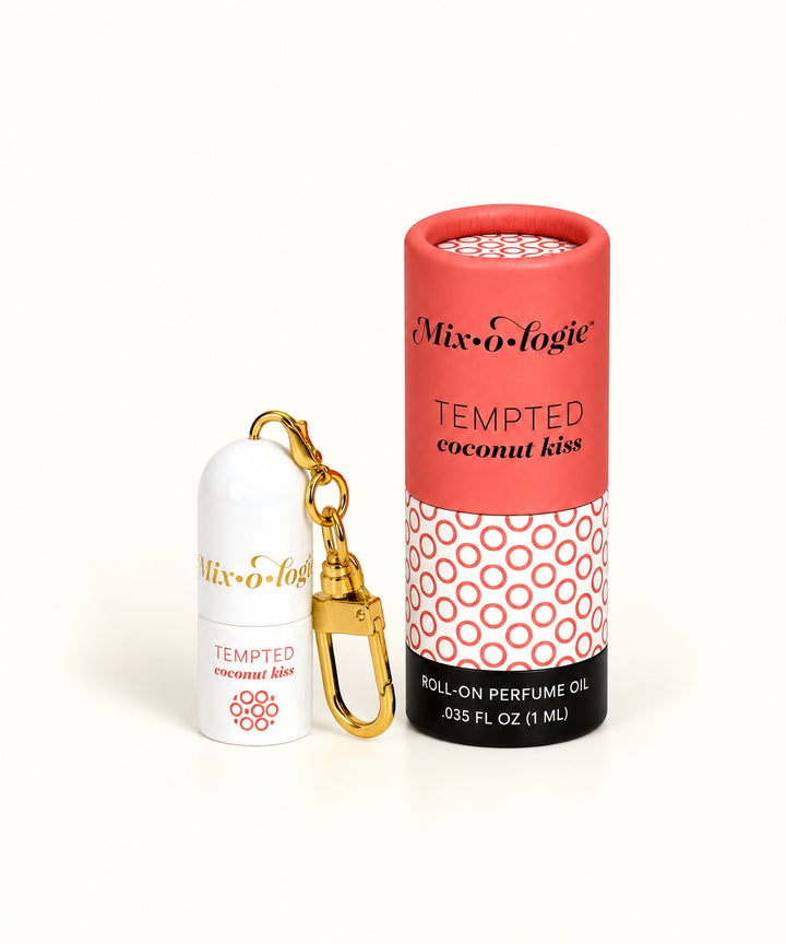 Mixologie Tempted Coconut Kiss 1 mL roll-on perfume oil keychain with gold clip and coral pink cylindrical packaging.