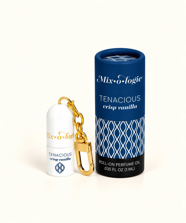 Mixologie Tenacious Crisp Vanilla mini perfume rollerball keychain with gold clasp and navy blue patterned packaging.