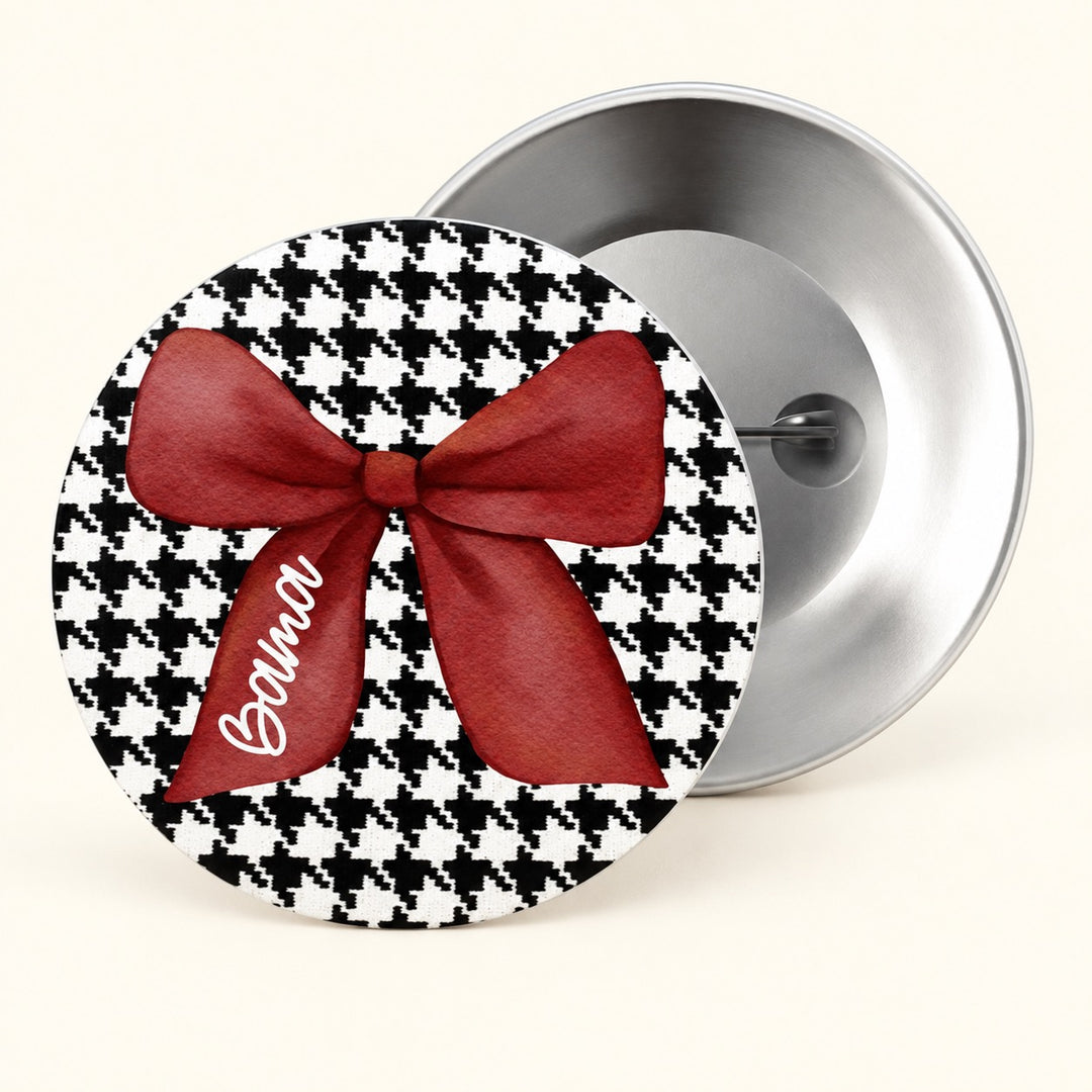 A round pin-back button shown from the front and back. The front features a black and white houndstooth pattern with a large red satin bow and the word &
