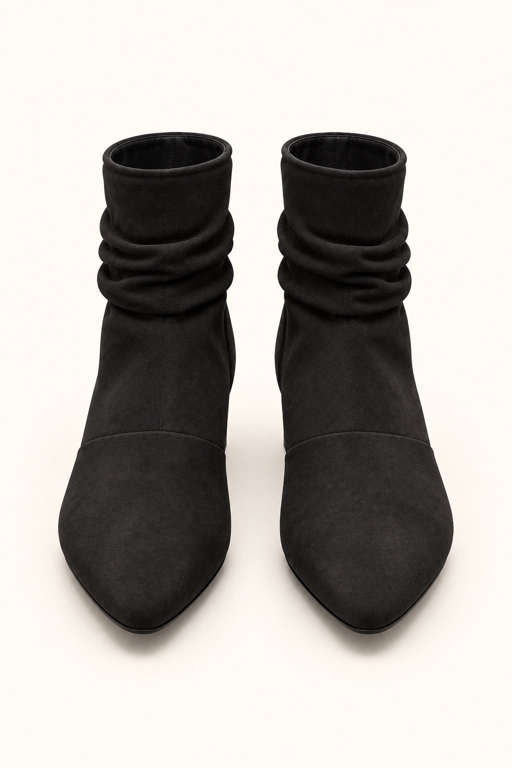 Front view of black pointed-toe slouch boots featuring gathered shafts and a soft suede finish.