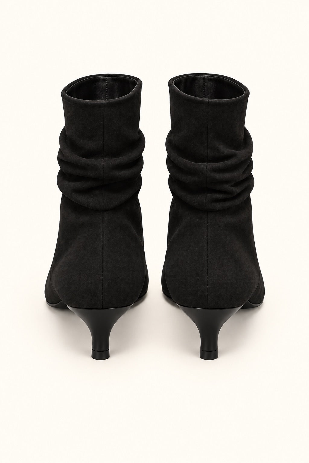 Rear view of black slouch ankle boots showing center seams and slim kitten heels.