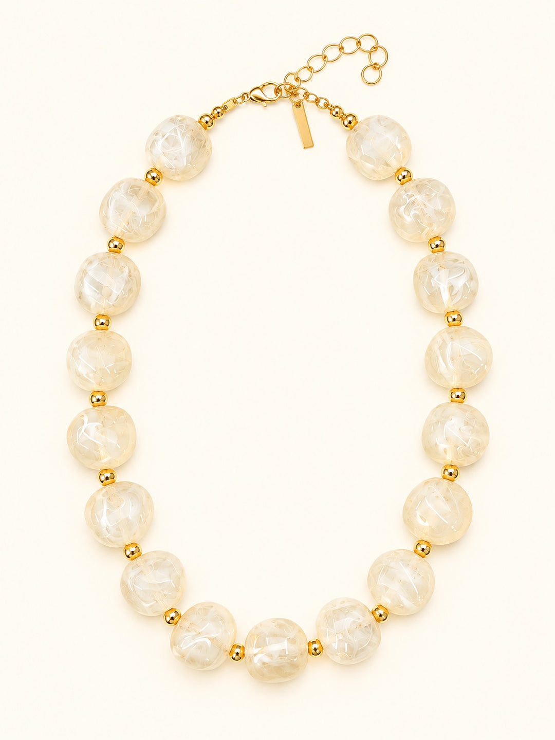 Lindon Cream Chunky Beaded Necklace with glossy ivory marbled resin beads, gold-tone spacers, lobster clasp, and adjustable extender chain.