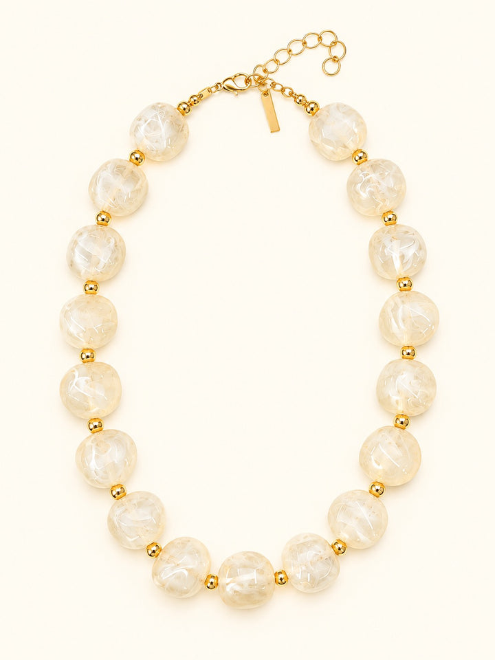Lindon Cream Chunky Beaded Necklace with glossy ivory marbled resin beads, gold-tone spacers, lobster clasp, and adjustable extender chain.