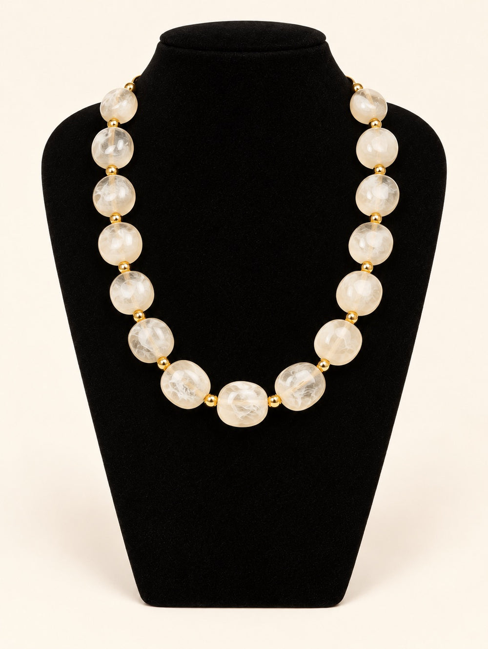 Lindon Cream Statement Beaded Necklace featuring oversized translucent ivory resin beads and gold-tone accents displayed on black velvet at Square 1 Boutique.