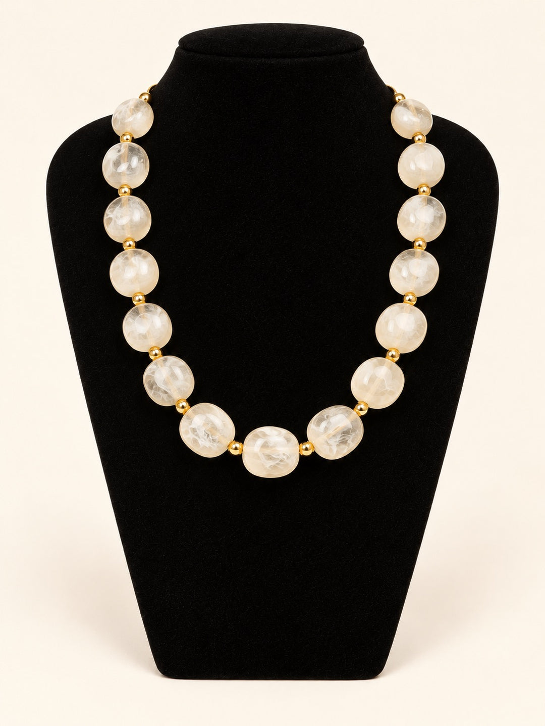 Lindon Cream Statement Beaded Necklace featuring oversized translucent ivory resin beads and gold-tone accents displayed on black velvet at Square 1 Boutique.