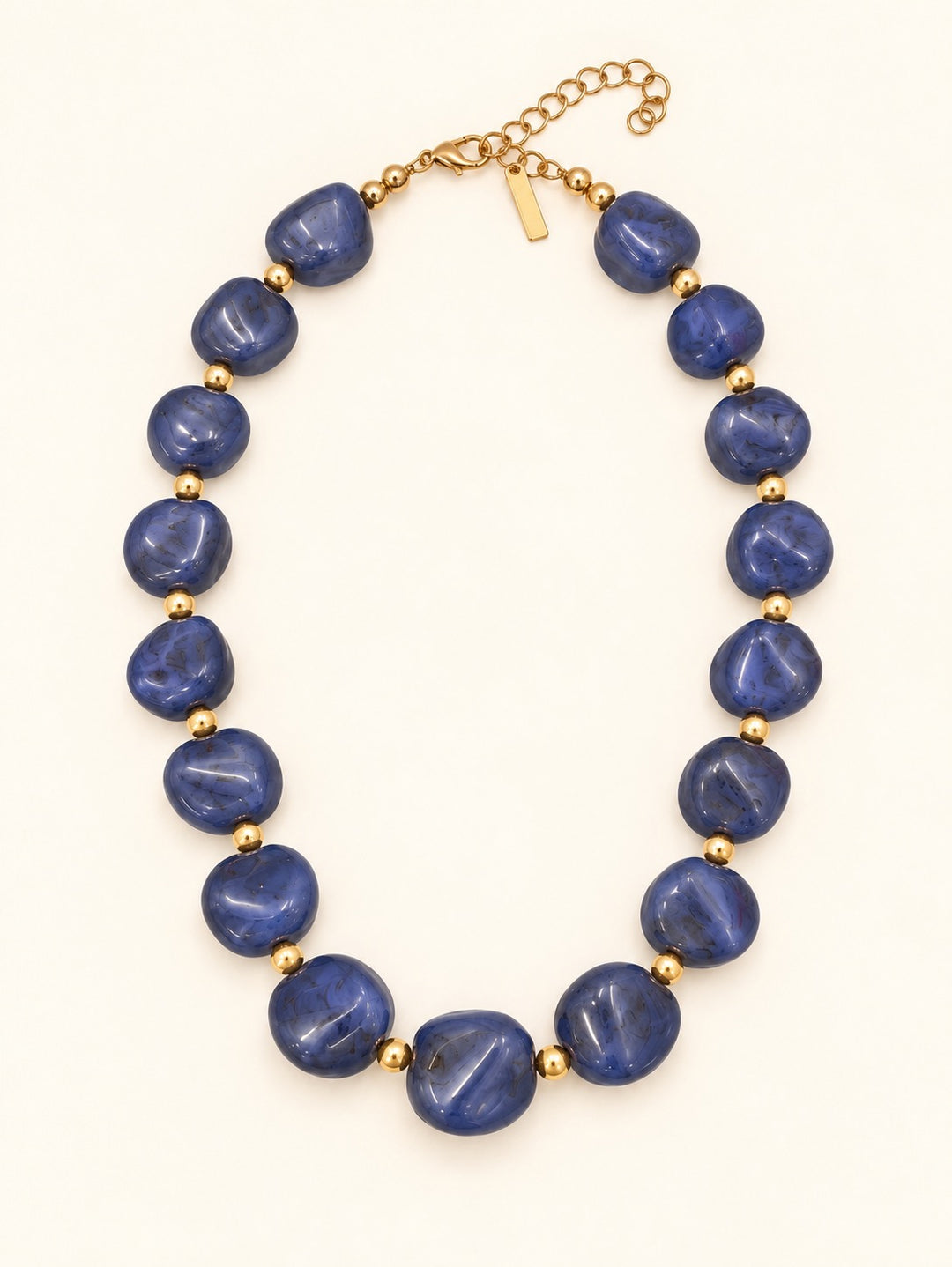 Lindon Blue Chunky Resin Beaded Necklace with oversized glossy blue beads, gold-tone spacers, and a 3-inch adjustable extender.