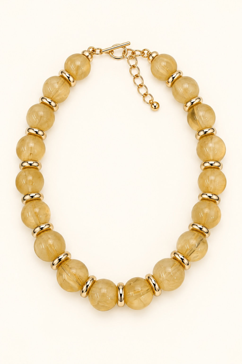 Sellah Olive Beaded Statement Necklace featuring golden-olive resin beads, gold-tone ring spacers, and adjustable extender chain photographed on a cream background.