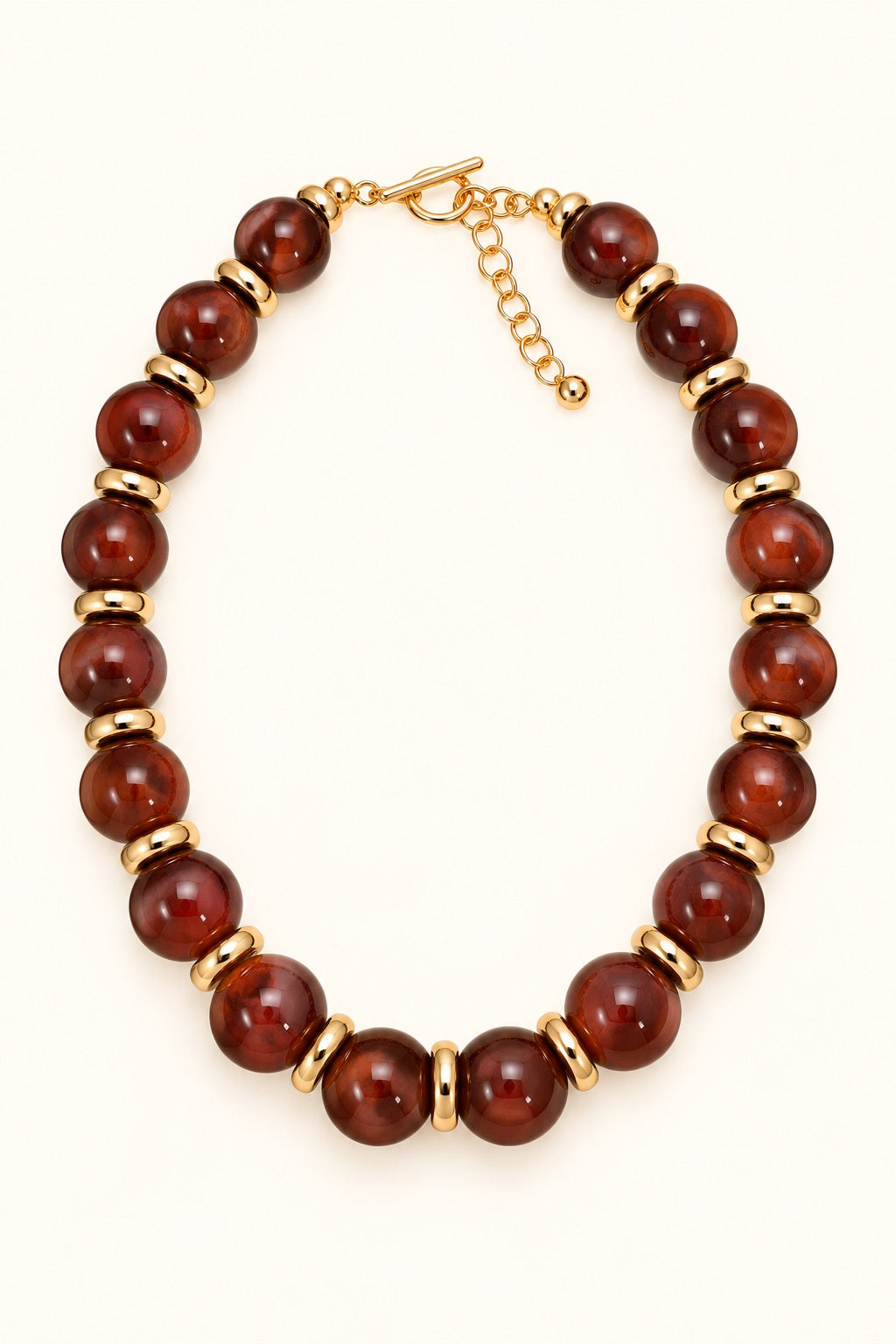 Sellah Olive Beaded Statement Necklace featuring golden-olive resin beads, gold-tone ring spacers, and adjustable extender chain photographed on a cream background.