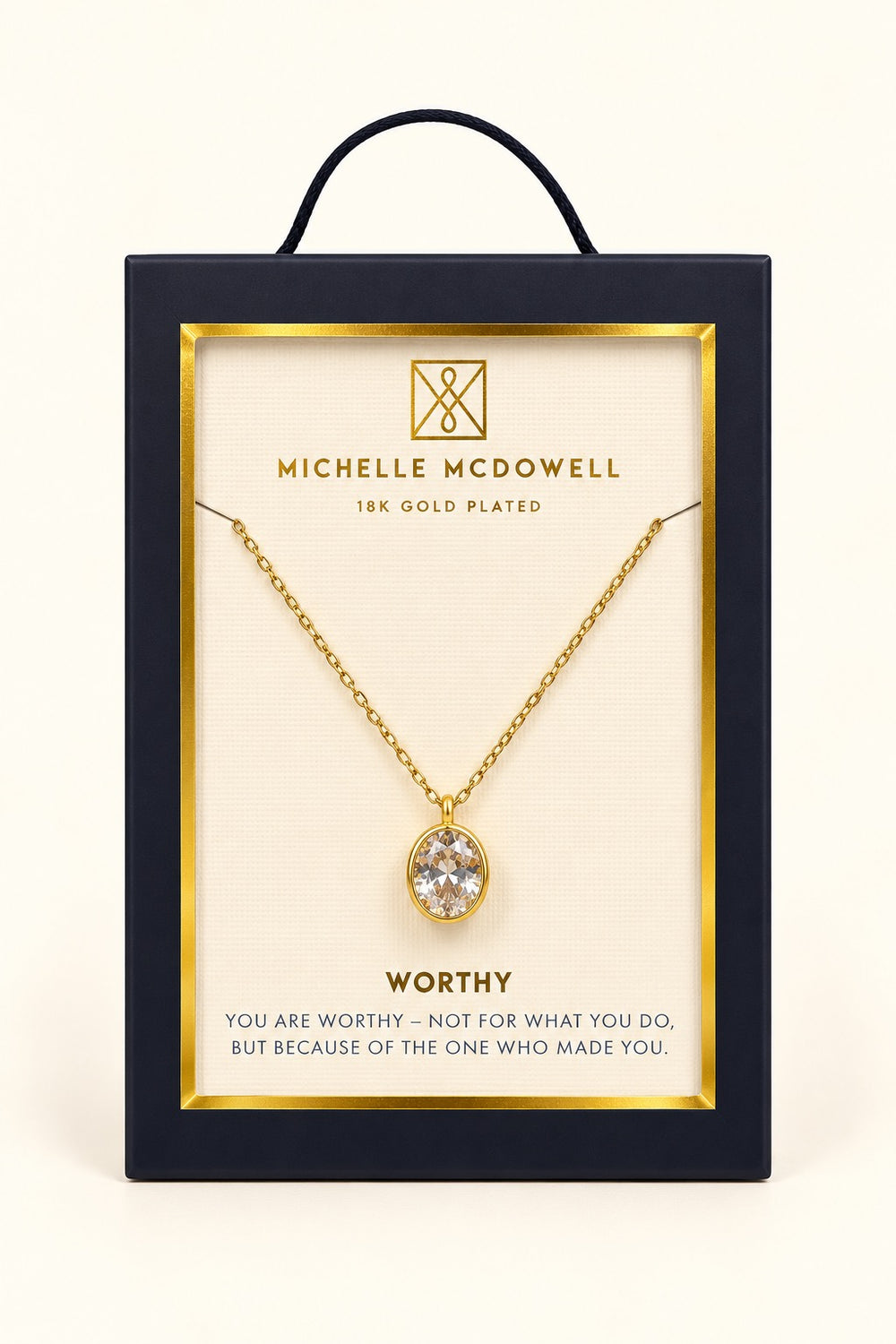 Michelle McDowell Valued Gold Pendant Necklace in branded gift packaging with a Worthy inspirational sentiment card, featuring an oval clear stone pendant and delicate gold-plated chain.