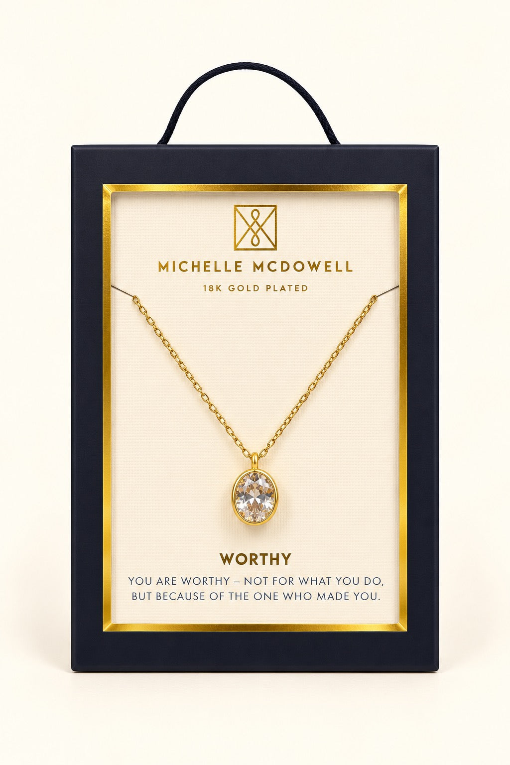 Michelle McDowell Valued Gold Pendant Necklace in branded gift packaging with a Worthy inspirational sentiment card, featuring an oval clear stone pendant and delicate gold-plated chain.