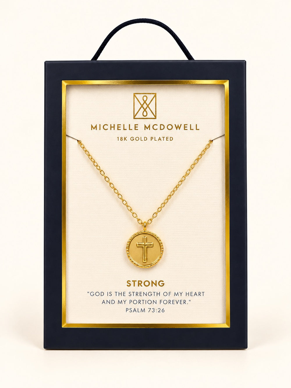 Michelle McDowell Saved Gold Cross Necklace in branded gift packaging featuring an 18K gold-plated chain, round cross pendant, and Strong inspirational scripture card with Psalm 73:26.