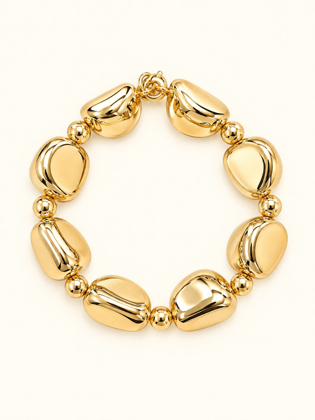 Rosalie Medium Gold Beaded Stretch Bracelet featuring sculptural rounded gold-tone resin beads and polished gold spacer accents, photographed on a cream background.