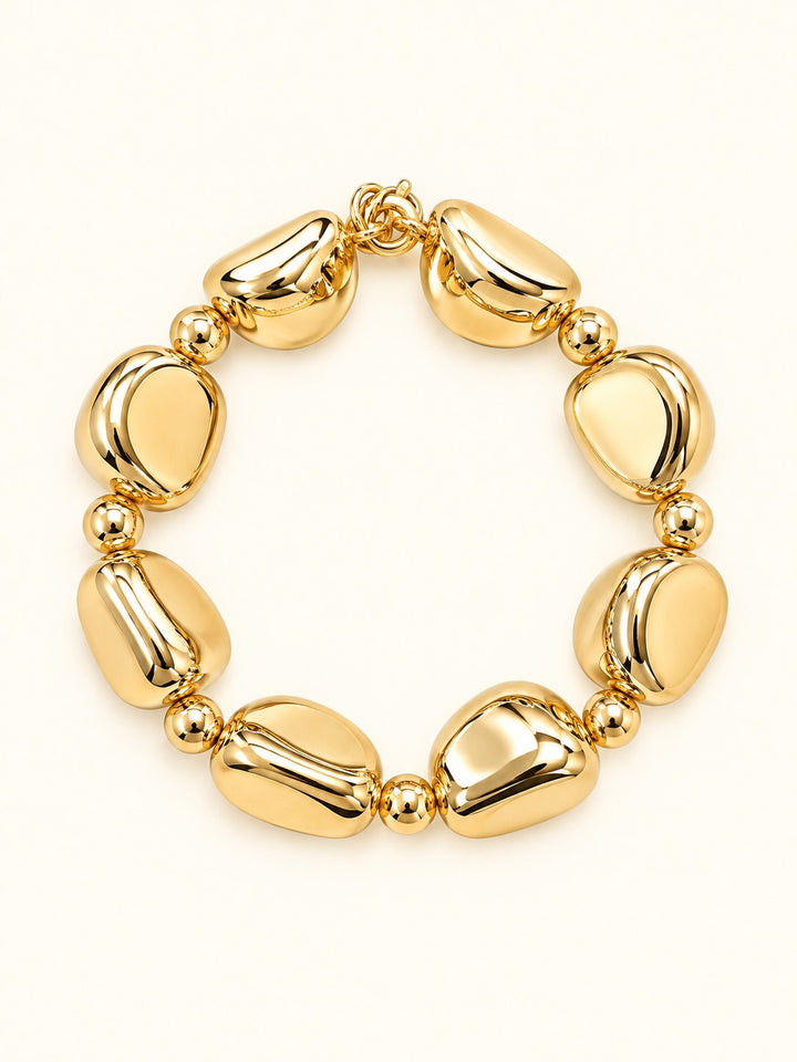 Rosalie Medium Gold Beaded Stretch Bracelet featuring sculptural rounded gold-tone resin beads and polished gold spacer accents, photographed on a cream background.