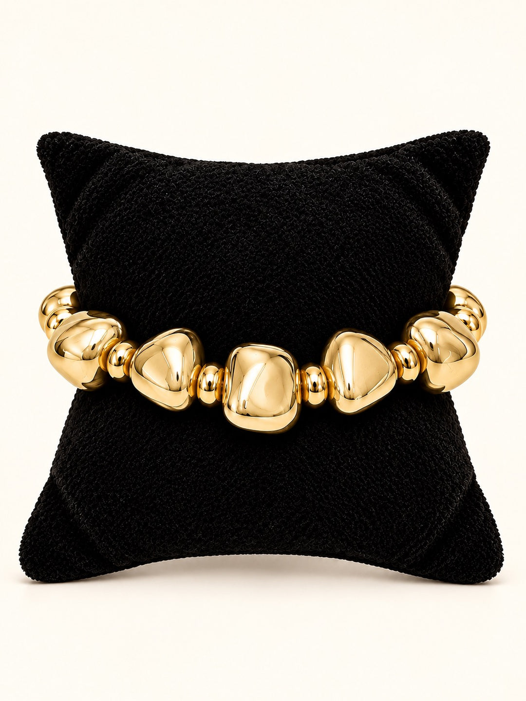 Rosalie Beaded Bracelet Medium featuring chunky polished gold geometric beads with smaller gold spacers, displayed on a black velvet jewelry pillow at Square 1 Boutique.