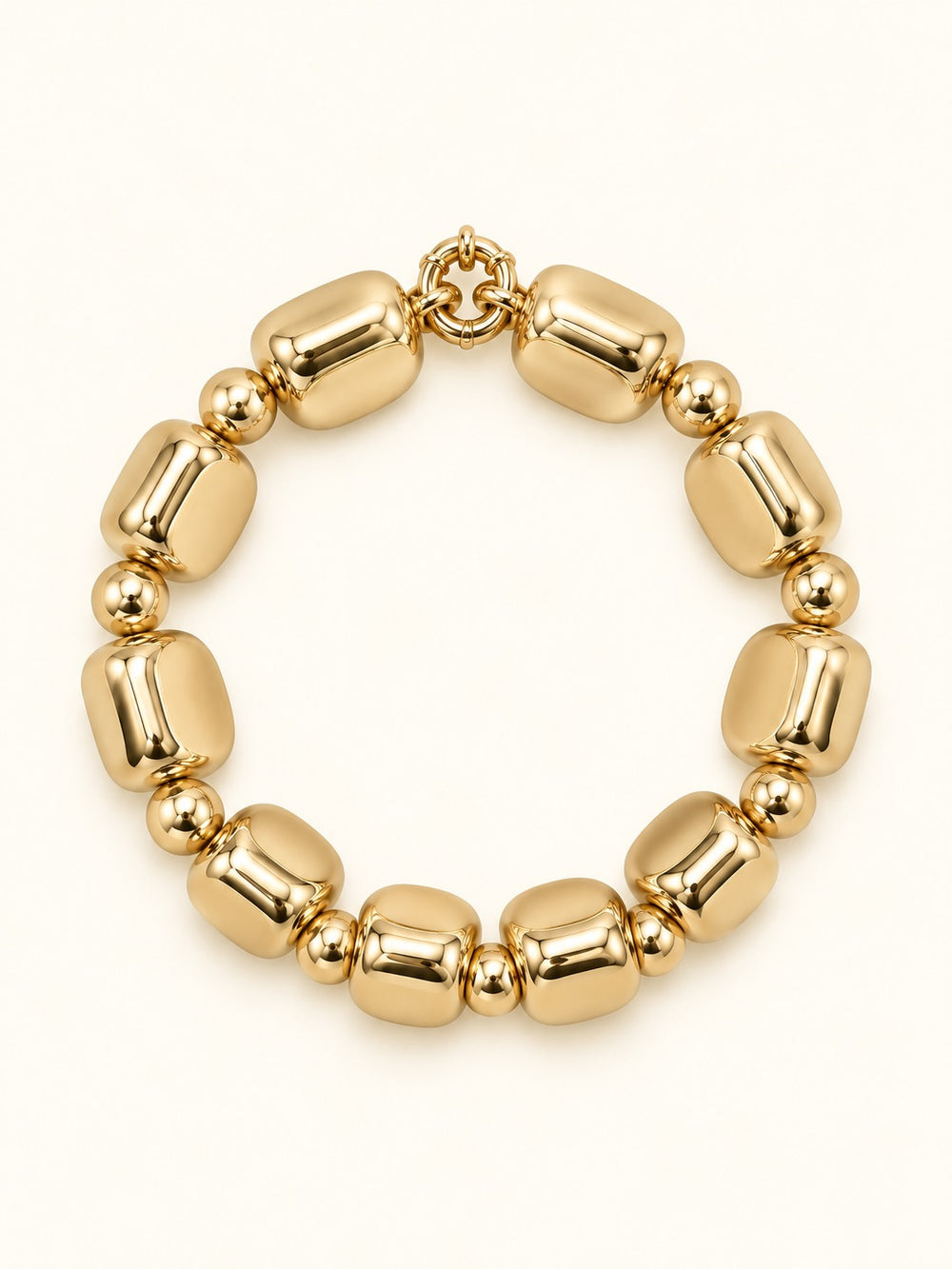 Rosalie Small Gold Beaded Bracelet featuring chunky rounded-square gold-tone beads with polished round spacer accents and a circular bracelet design on a cream studio background.