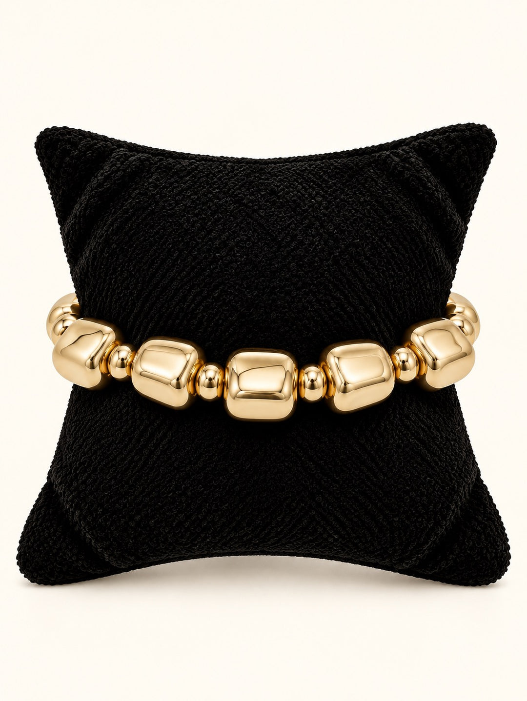 Rosalie Beaded Bracelet Small by Michelle McDowell featuring polished gold rounded-square beads and smaller gold spacers displayed on a black velvet jewelry pillow at Square 1 Boutique.