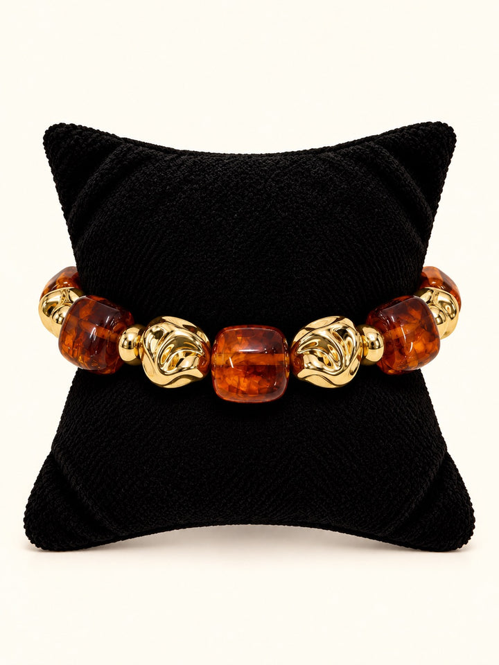 Layla Tortoise Bracelet featuring oversized translucent amber-brown beads alternating with sculptural polished gold-tone beads, arranged in a circle on a cream studio background at Square 1 Boutique.