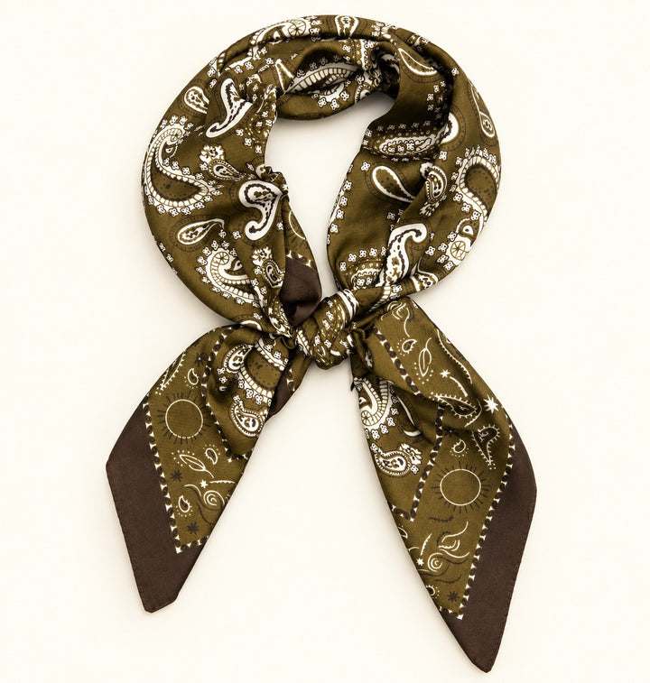 Olive paisley border scarf tied in a neck scarf style with white and brown paisley detailing on a cream background.