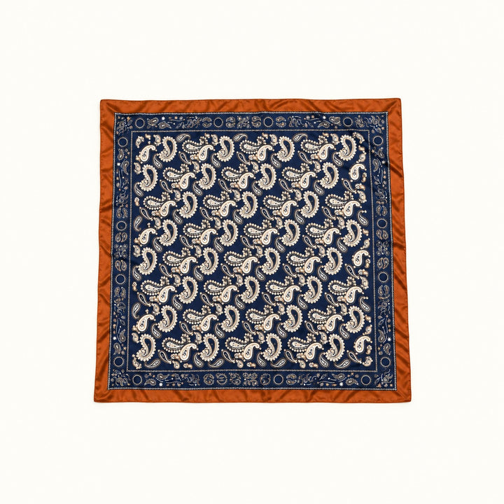 Navy paisley border scarf fully opened in a square flat lay, featuring cream paisley print, decorative navy border, and rust brown trim on a cream background.