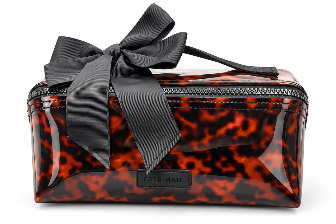 Case-Mate tortoiseshell cosmetic bag featuring a glossy brown and black tortoise pattern, black zip closure, top handle, oversized black bow, and Case-Mate logo patch